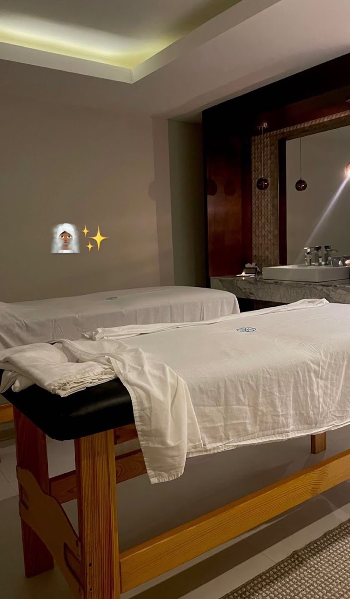 A warm, dimly lit massage room with two treatment tables